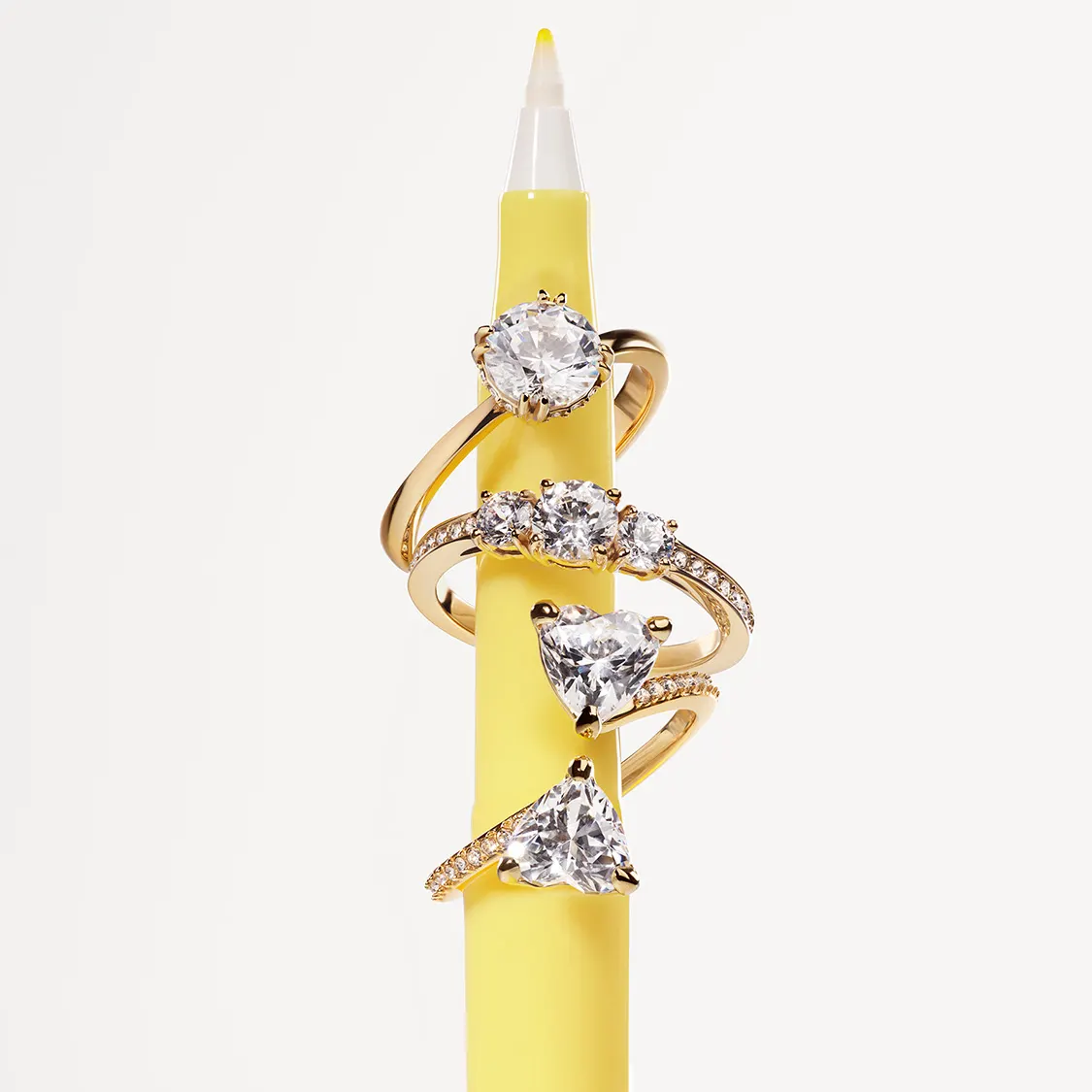 A yellow pen with three Swarovski gold-tone rings hanging on it