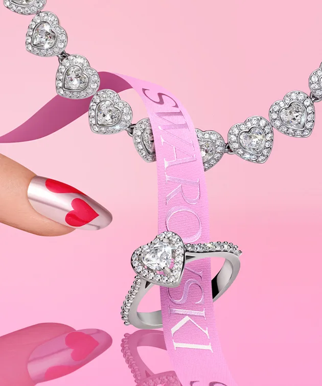 Heart-shaped jewelry on pink background with pink ribbon