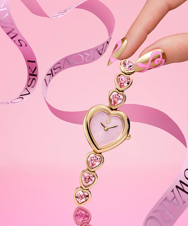 Fingers reaching for heart-shaped watch on pink background