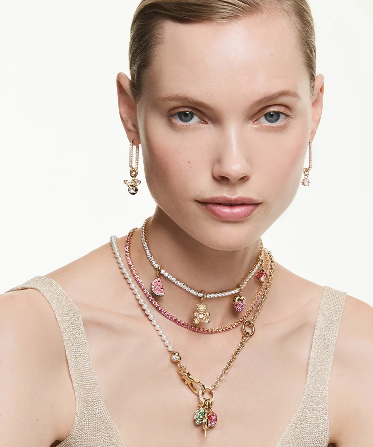 Model wearing charm necklaces