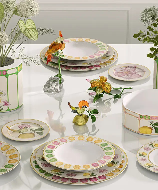 Dining table set with flamboyant Swarovski x Rosenthal plates and decorated with bright, colorful Swarovski crystal flowers and animal figurines