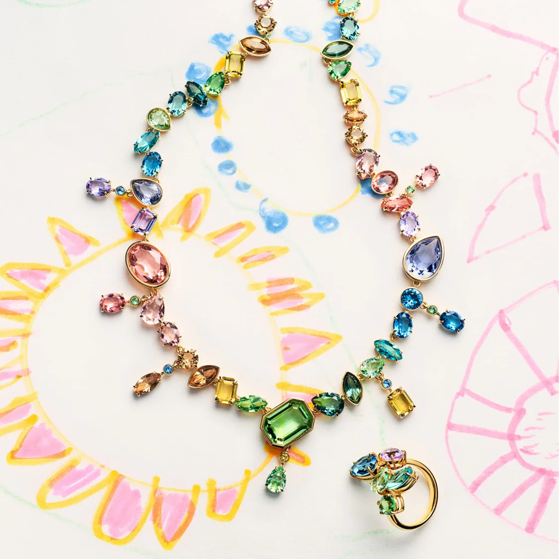 Gema necklace and cocktail ring on top of childlike drawing
