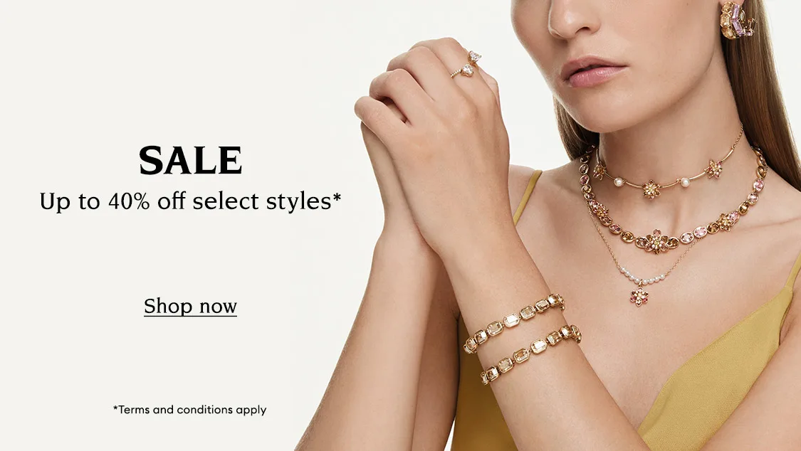 Model wearing Swarovski jewelry. Text reads “SALE Up to 40% off select styles* *Terms and conditions apply”. Clickable button reads “Shop now”