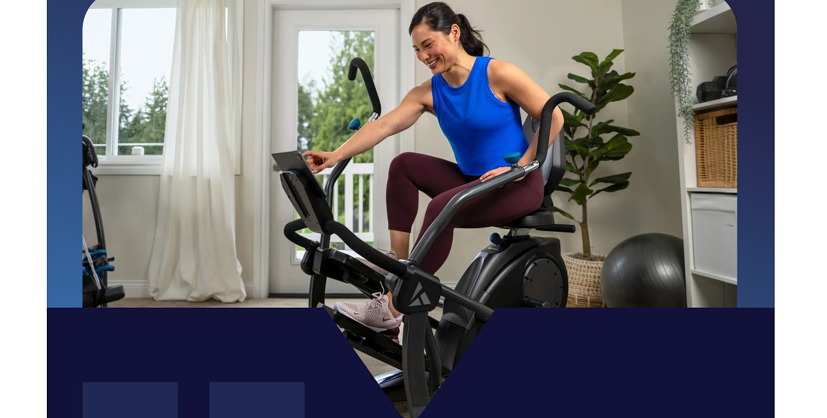 Woman exercising on an elliptical machine in a bright room.