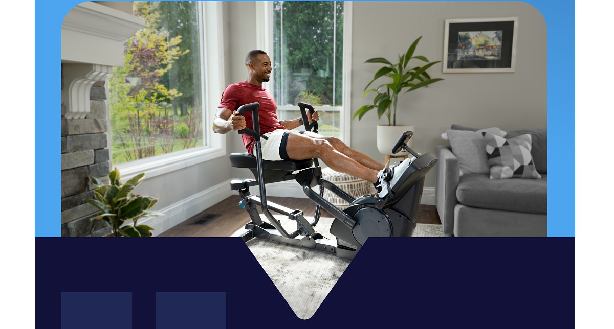 Man exercising on a fitness machine in a bright living room.