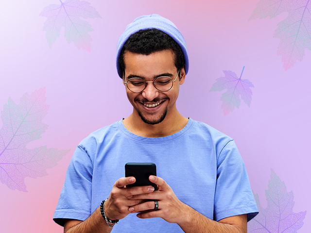 A young man smiling with a phone in hand