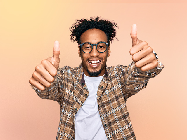 Man with a cheerful expression giving the thumbs-up gesture