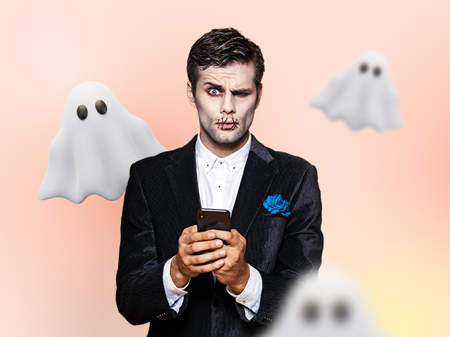 A man dressed in a Halloween costume with a phone in his hand and ghosts in the background