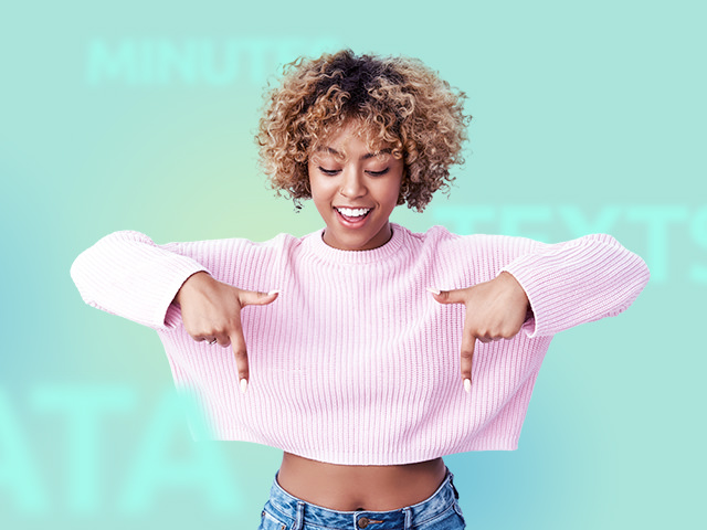 A young woman smiling and pointing down towards the video snapshot below