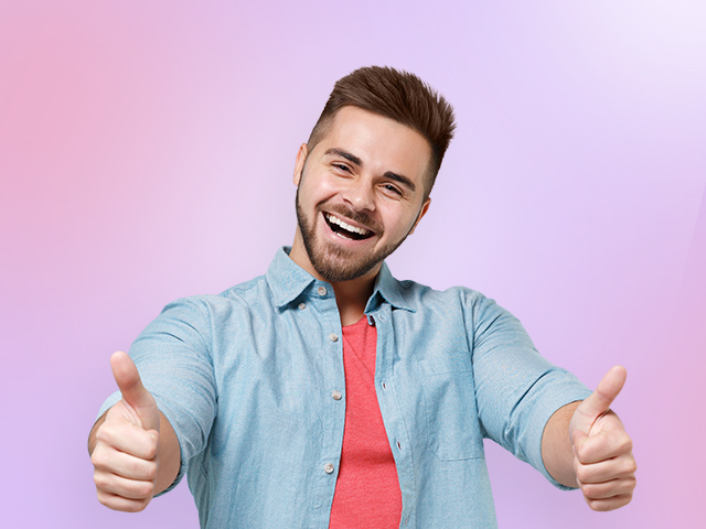 A cheerful man giving a thumbs-up gesture with both hands
