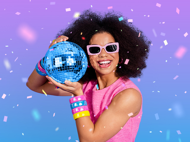 A girl dressed in retro disco theme clothing and with a disco ball in hand
