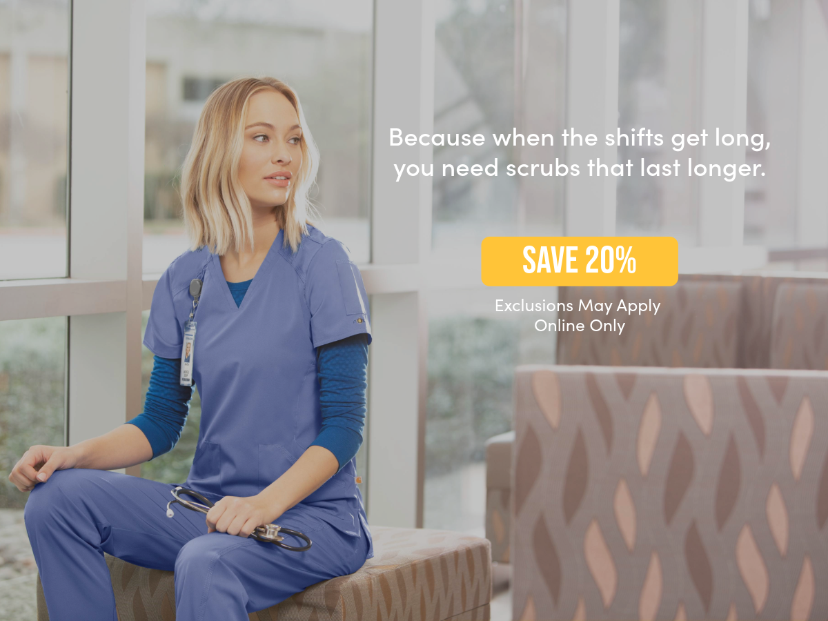 a woman in blue scrubs sitting on a couch next to a window