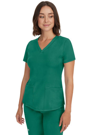 Woman wearing Healing Hands scrubs in color Hunter Green. 