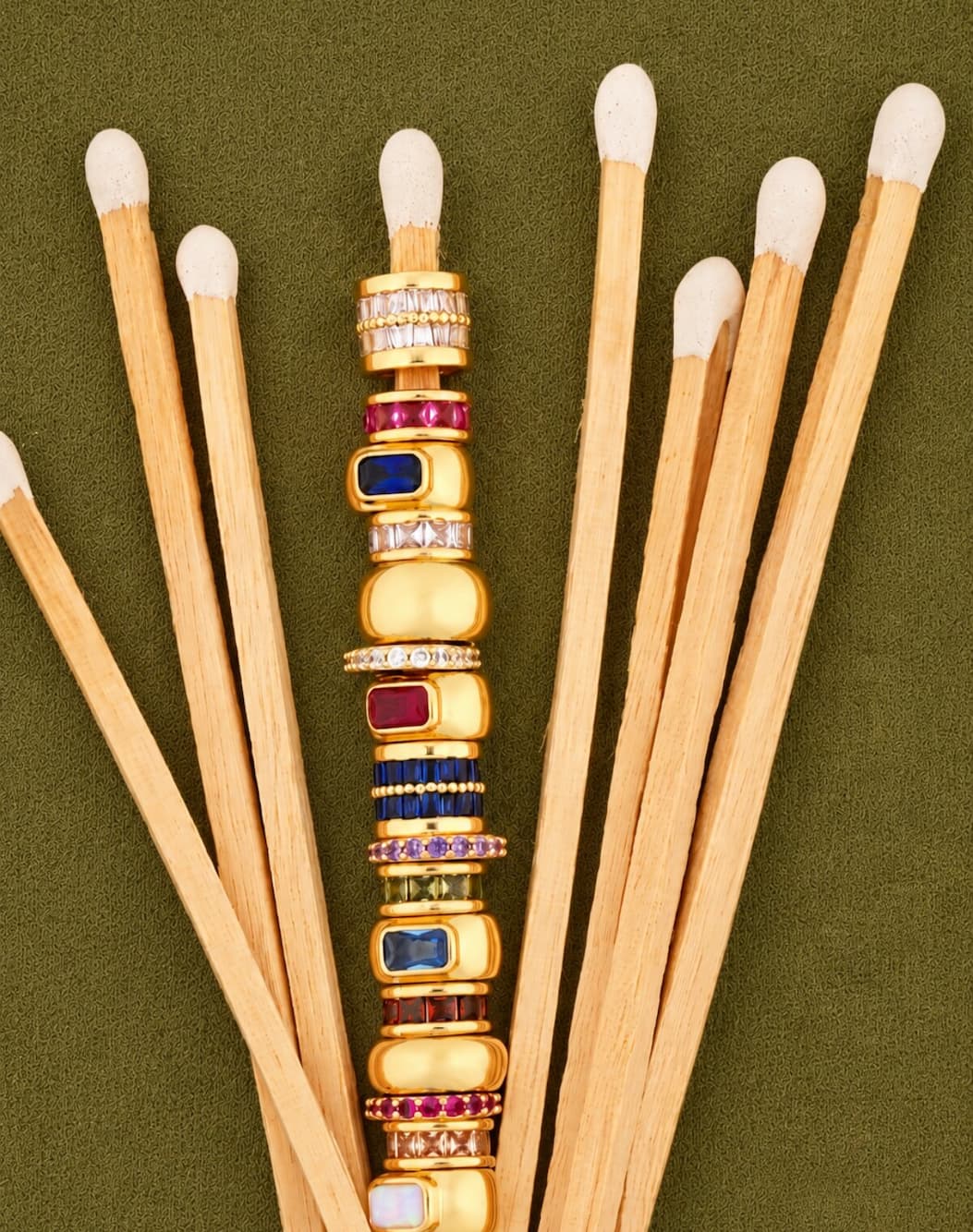 Photo of birthstone spacers layered on a match stick