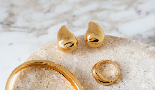 Product image showing jewelry pieces from the Bold Elegance collection: earring, ring, and bracelet
