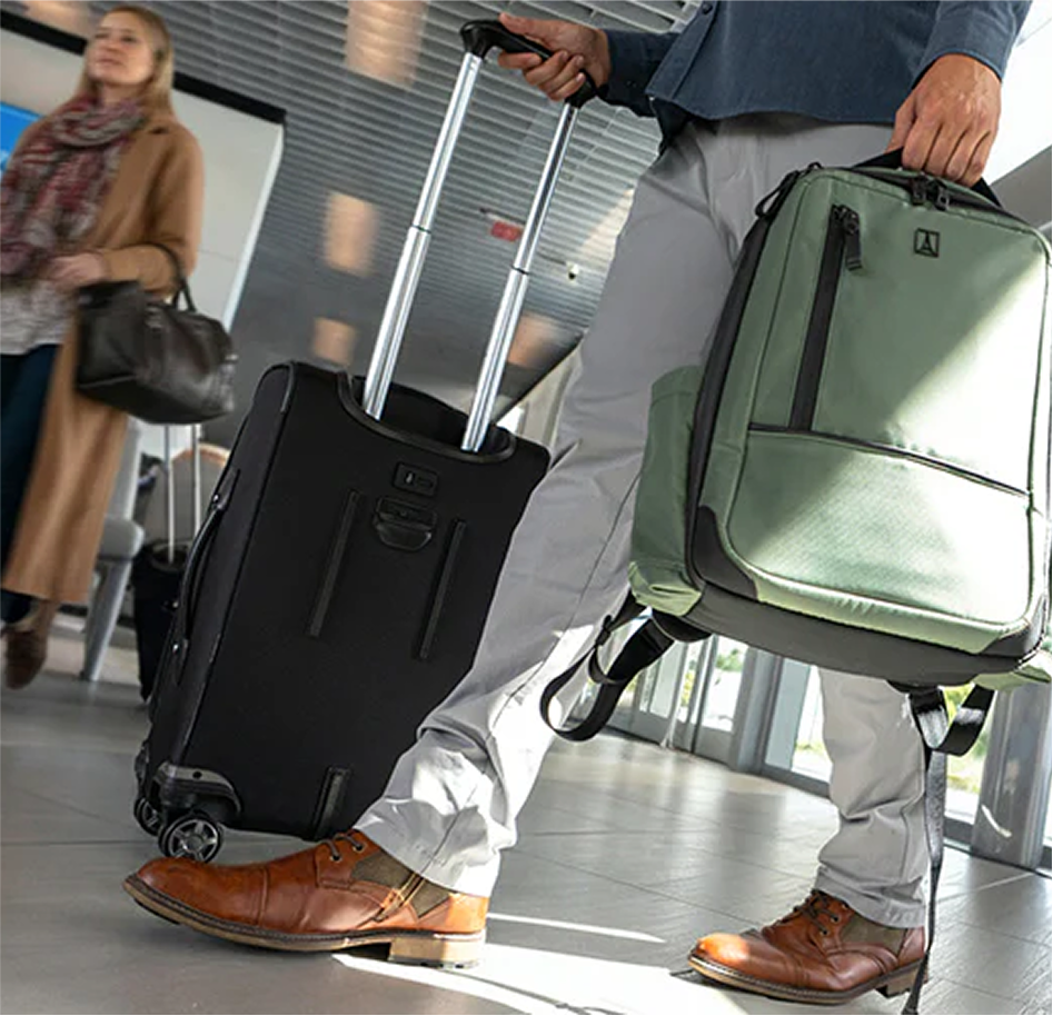 Tight image of man walking through an airport with his Travelpro luggage