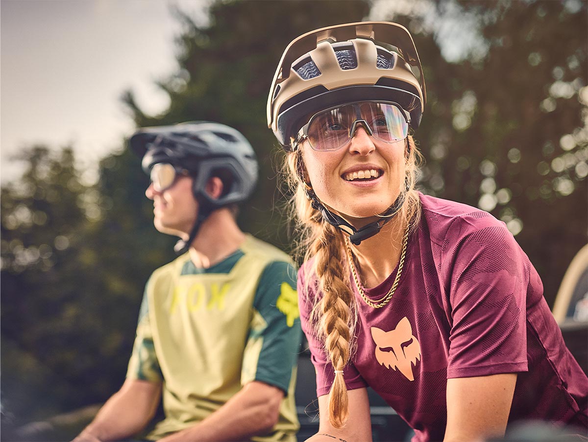 Cyclists wearing helmets while sitting on tailgate of truck