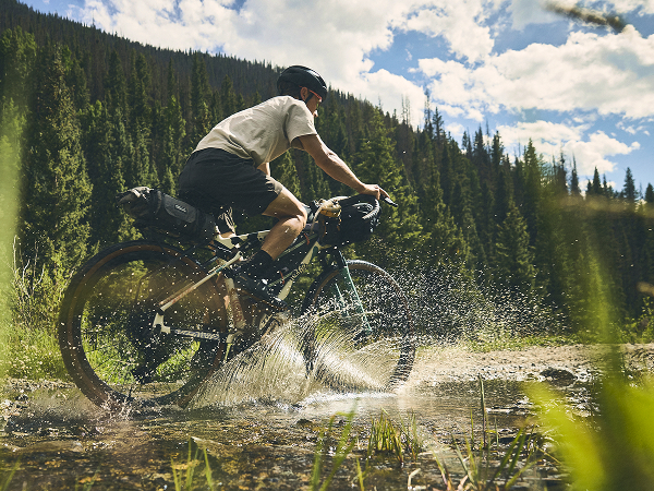 Lifestyle shot of a cyclist wearing a helmet on gravel bike