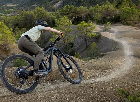 Lifestyle shot of two cyclists wearing helmets and sunglasses on mountain bikes