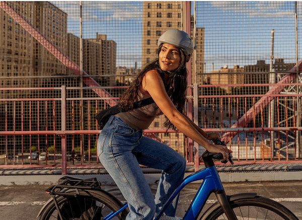 Lifestyle shot of a cyclist wearing a helmet on Electric bike