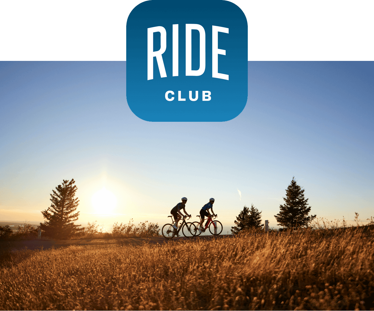 Ride Club logo over cyclists riding bikes at sunset