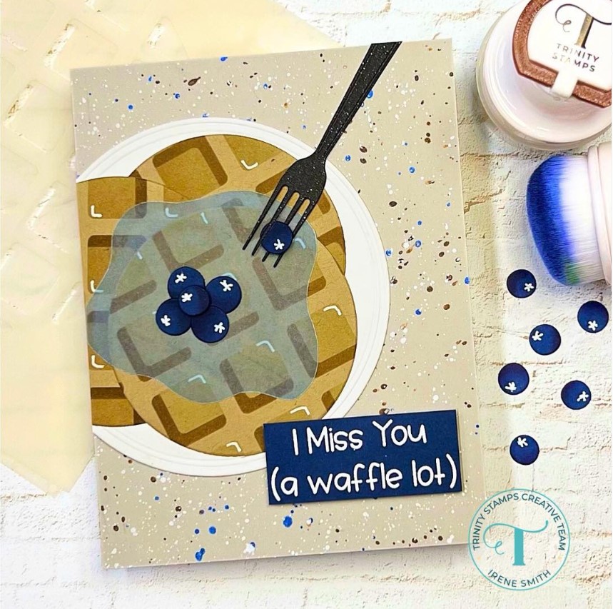 A tan-colored card featuring a plate of blueberry waffles with a note reading "I Miss You (a waffle lot)"