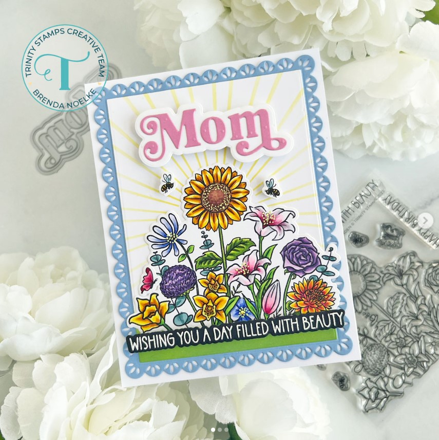 A colorful floral bouquet greeting card with a blue scalloped border and a message saying, "Mom wishing you a day filled with beauty"