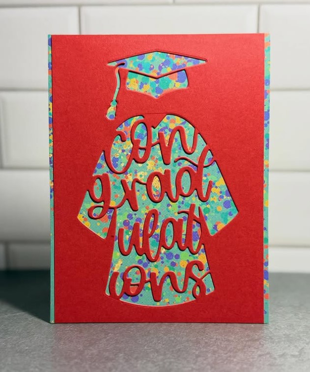 ConGRADulations Die Set featured in red with paint spackled background paper