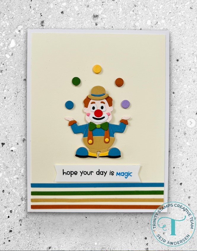 Tiny clown in muted tones juggling a few colored balls above a striped border with a message reading "hope your day is magic"