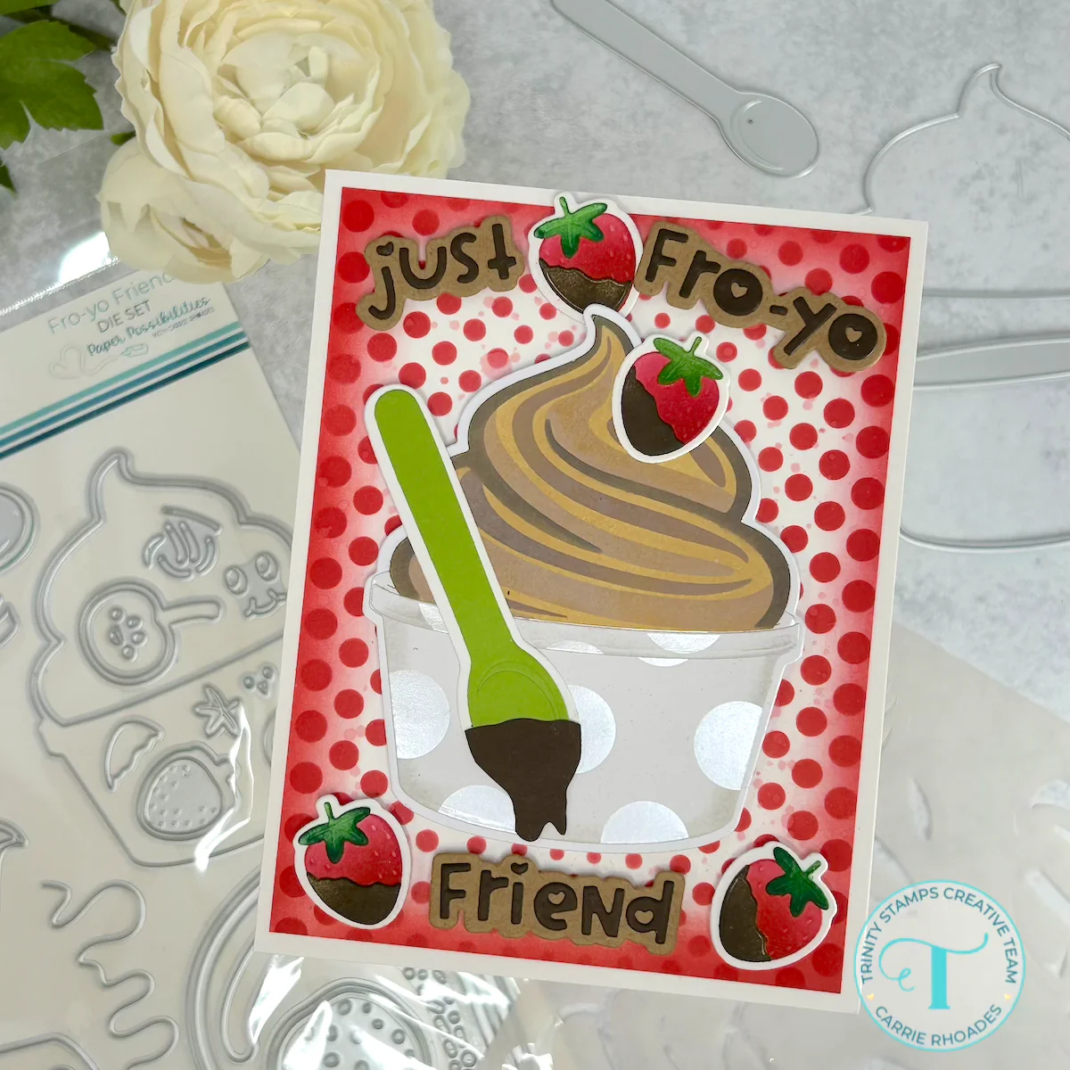 Chocolate frozen yogurt themed greeting card on red and white polka dot background with chocolate-dipped strawberries and a dripping green spoon