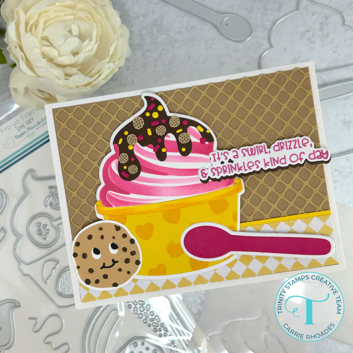 Pink and white frozen yogurt in a yellow cup with hearts on a waffle cone texture background. Topped with chocolate drizzle and chocolate chip cookies. Reads "it's a swirl, drizzle, & sprinkles kind of day"