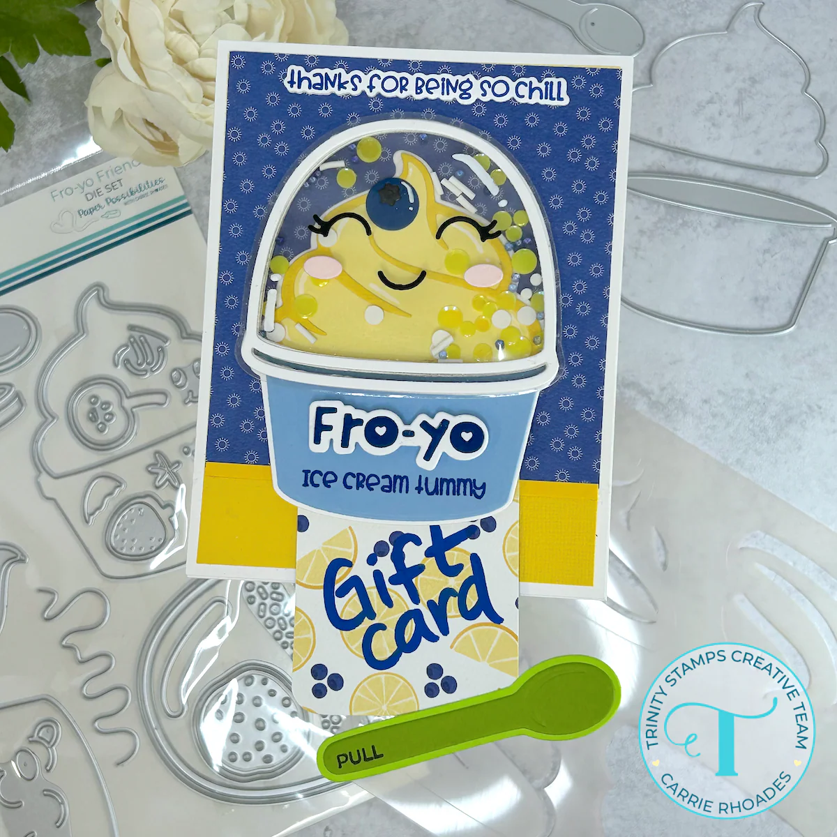 Blueberry-lemon frozen yogurt-themed greeting card with yellow yogurt, a clear lid with shaker elements inside, on a blue and yellow patterned paper background. Message reads, "Fro-yo ice cream tummy, thanks for being so chill"