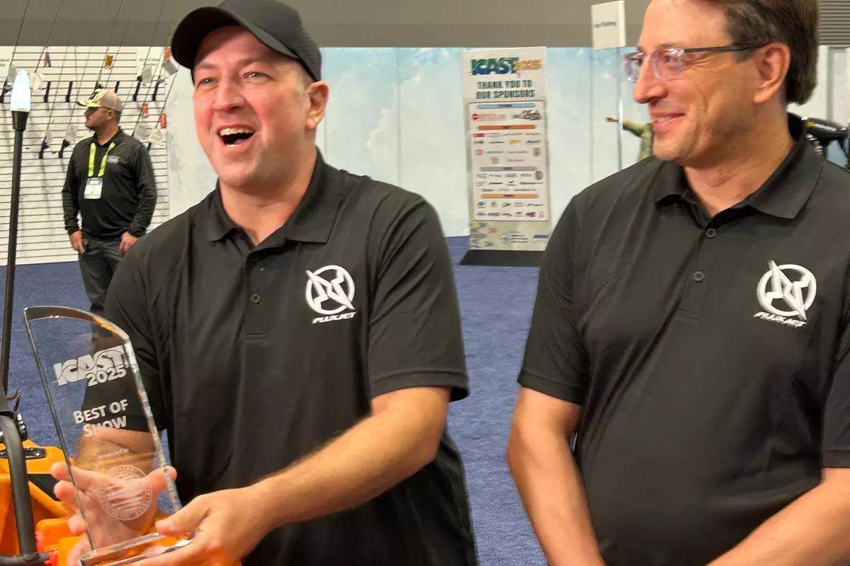 2 smiling men holding ICAST trophy