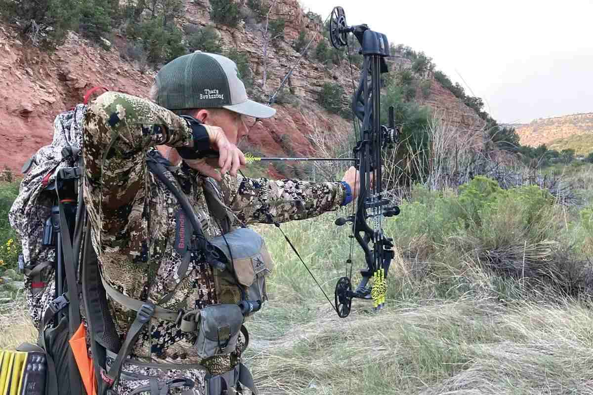 Hunter in camo shooting bow