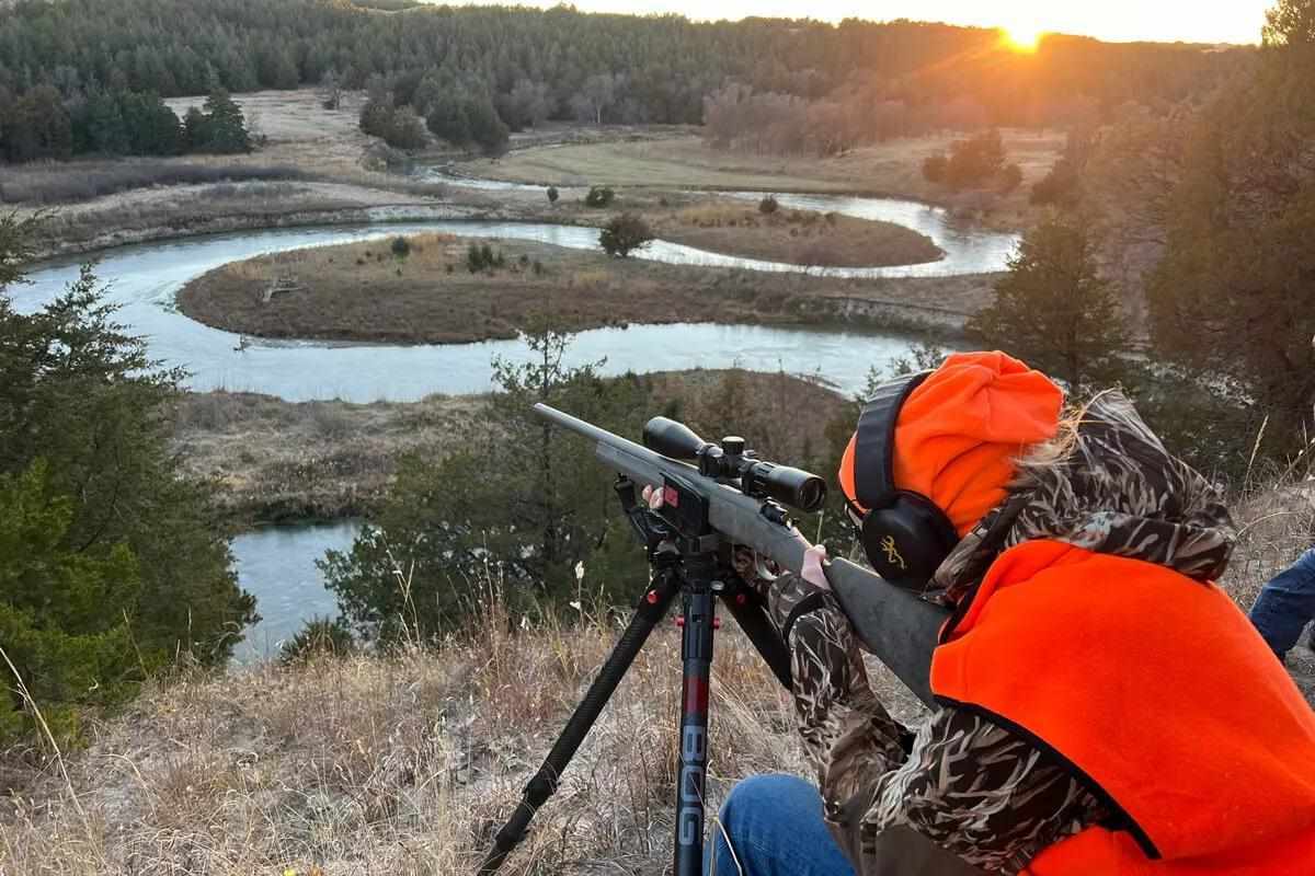 Man aiming on mountain side with riflescope