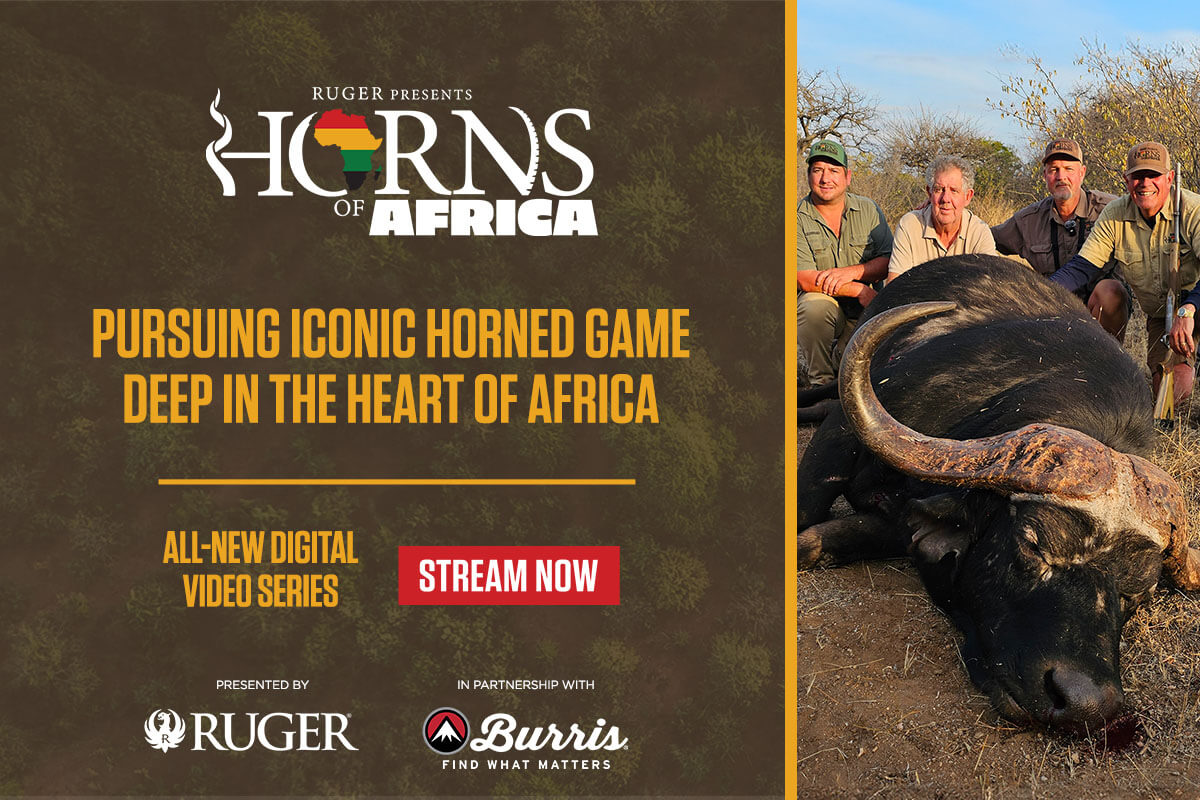 Men leaning on huge kill in Africa