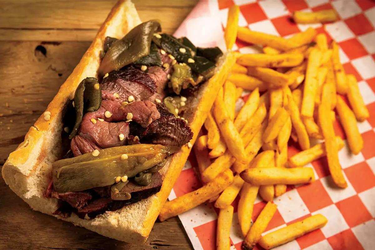 Image of sliced elk roast in delicious baguette with french fries