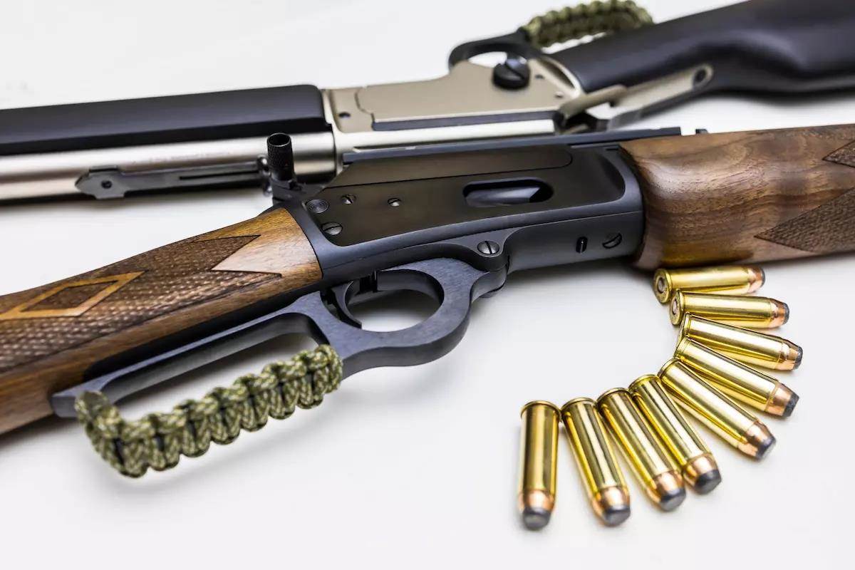 Two rifles and ammo displayed on white background