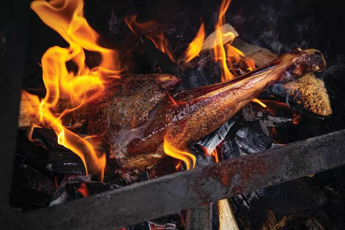 Venison shank over grill and flame