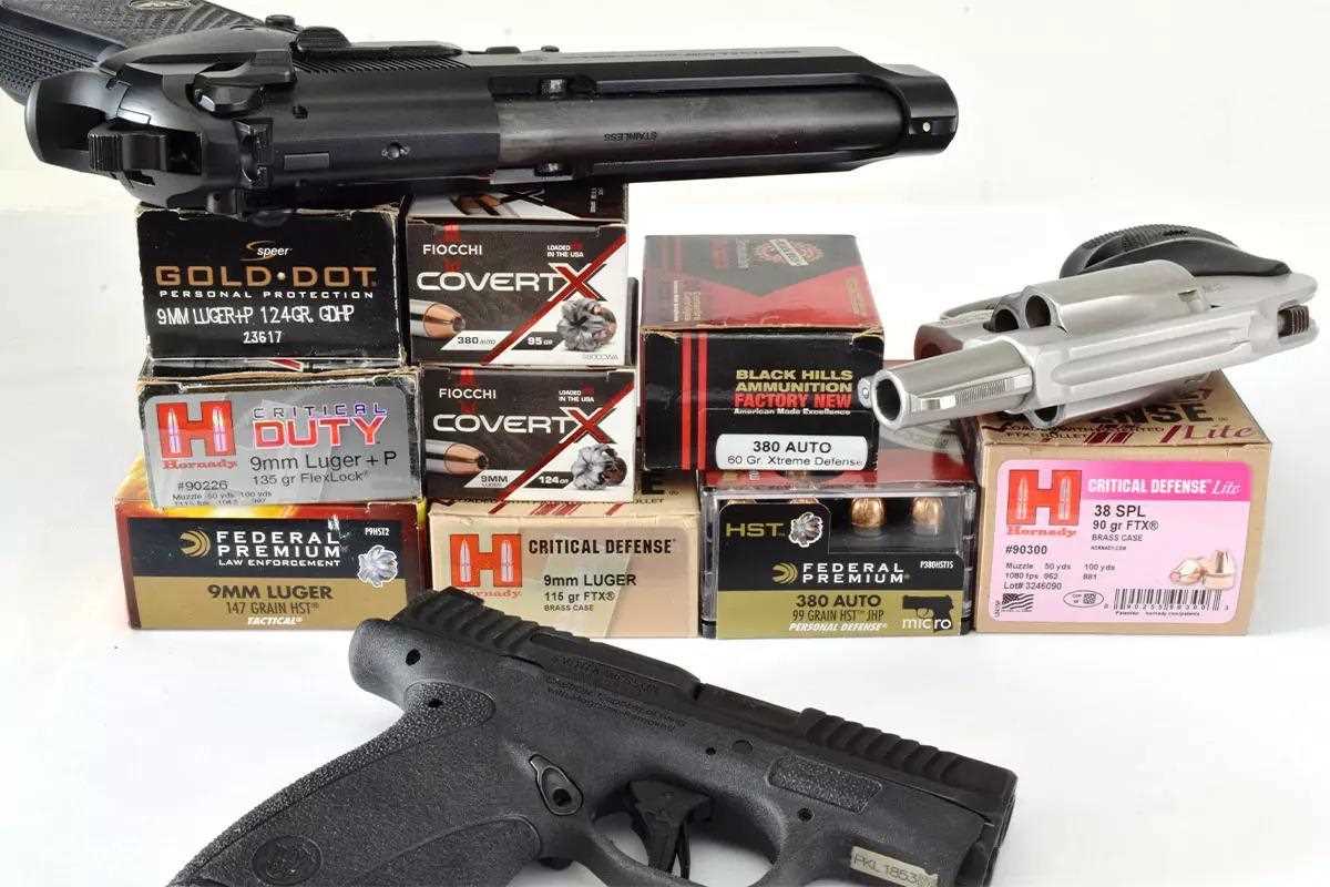 Different handguns displayed in multiple directions, on and beside boxes of ammunition