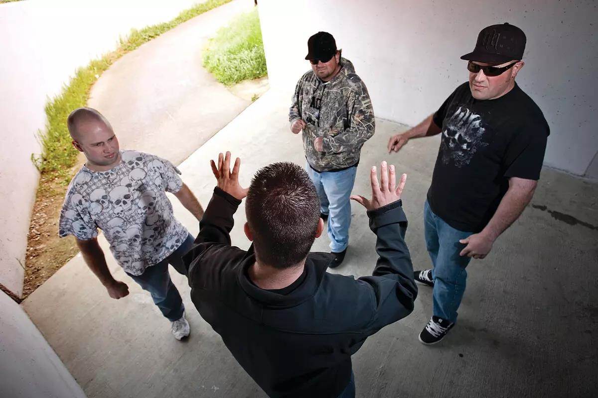 Man being confronted and threatened by a group of 3 men with aimed fists