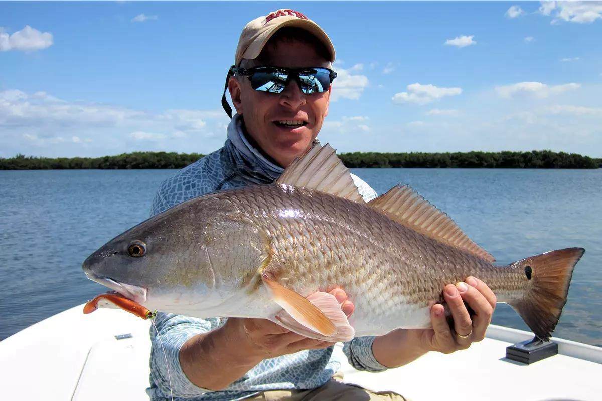 Captain Rick Grassett holding redfish caught on jig