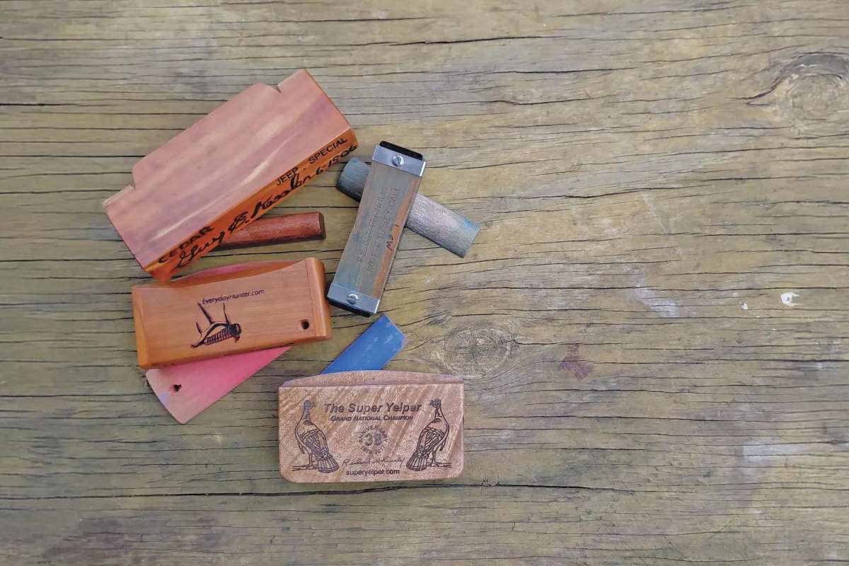 Several colorful turkey calls displayed on wooden background
