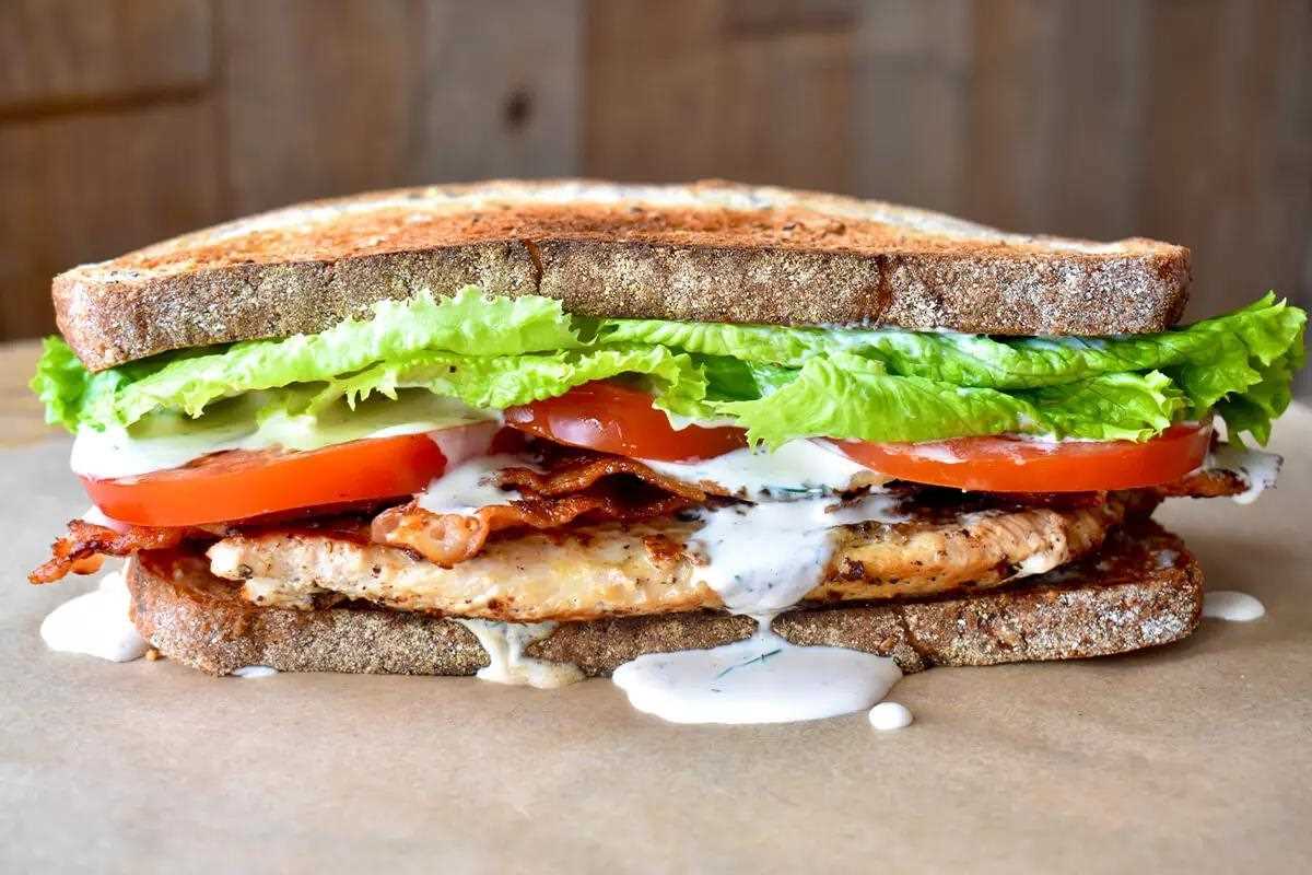Sandwich with turkey, bacon, lettuce, tomato, dressing