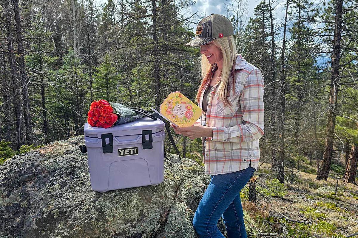 Woman outdoors in front of Yeti cooler and roses
