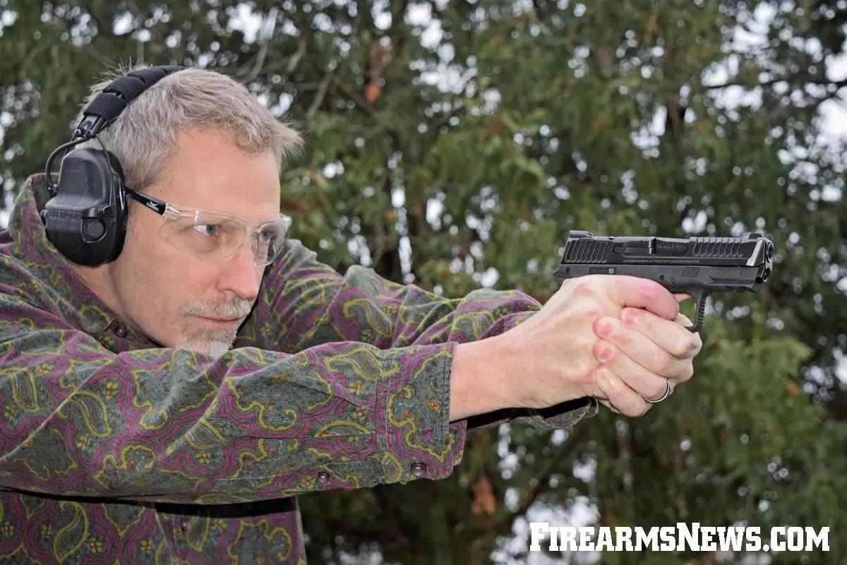 Man taiking aim with black Smith & Wesson 9mm