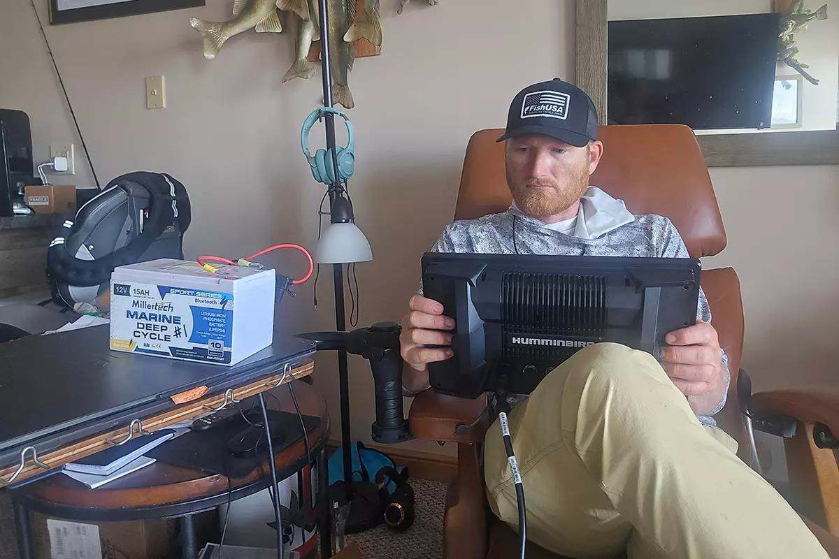 Pro fishing guide Ross Robertson sitting in chair looking at monitor