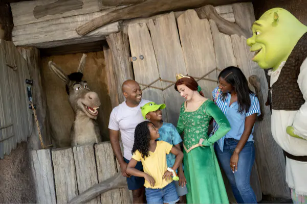 A family meet Shrek, Fiona and Donkey outside of Shrek’s cottage at Shrek’s Swamp Meet in DreamWorks Land at Universal Studios Florida. 