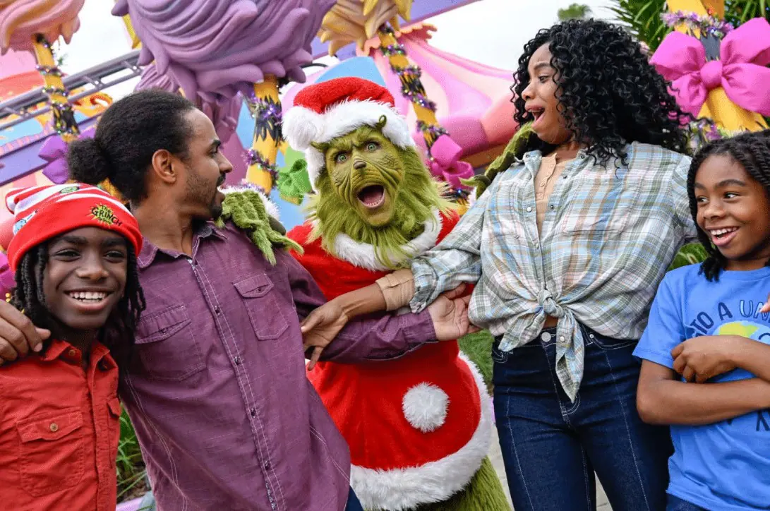 An image of guests celebrating with The Grinch™ during the Universal Holiday Tour.