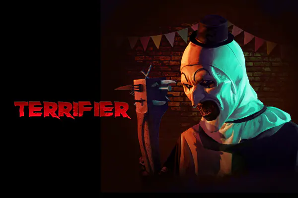 Art the Clown holding a club enhanced with sharp tools and utensils, in front of a brick wall with party flags, next to the word “TERRIFIER” in blotchy red letters.